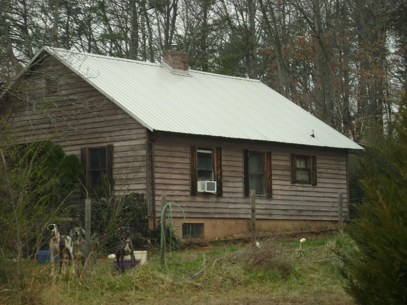 White metal roof on an old wood sided farmhouse, from a Metal Roof Installation job in Milford